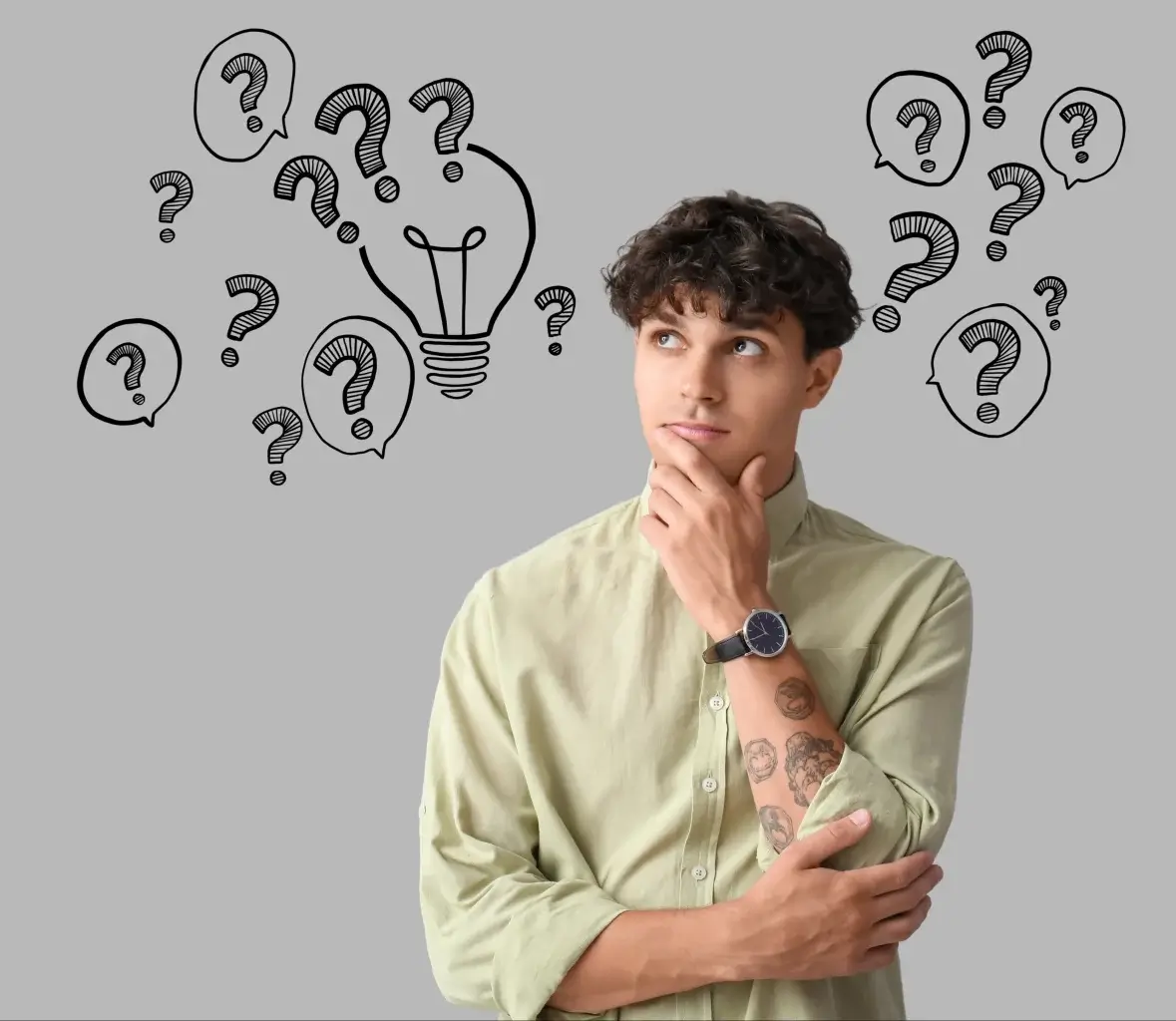 A young man with curly hair and a tattooed arm stands thinking, surrounded by illustrated question marks and a light bulb on a grey background.