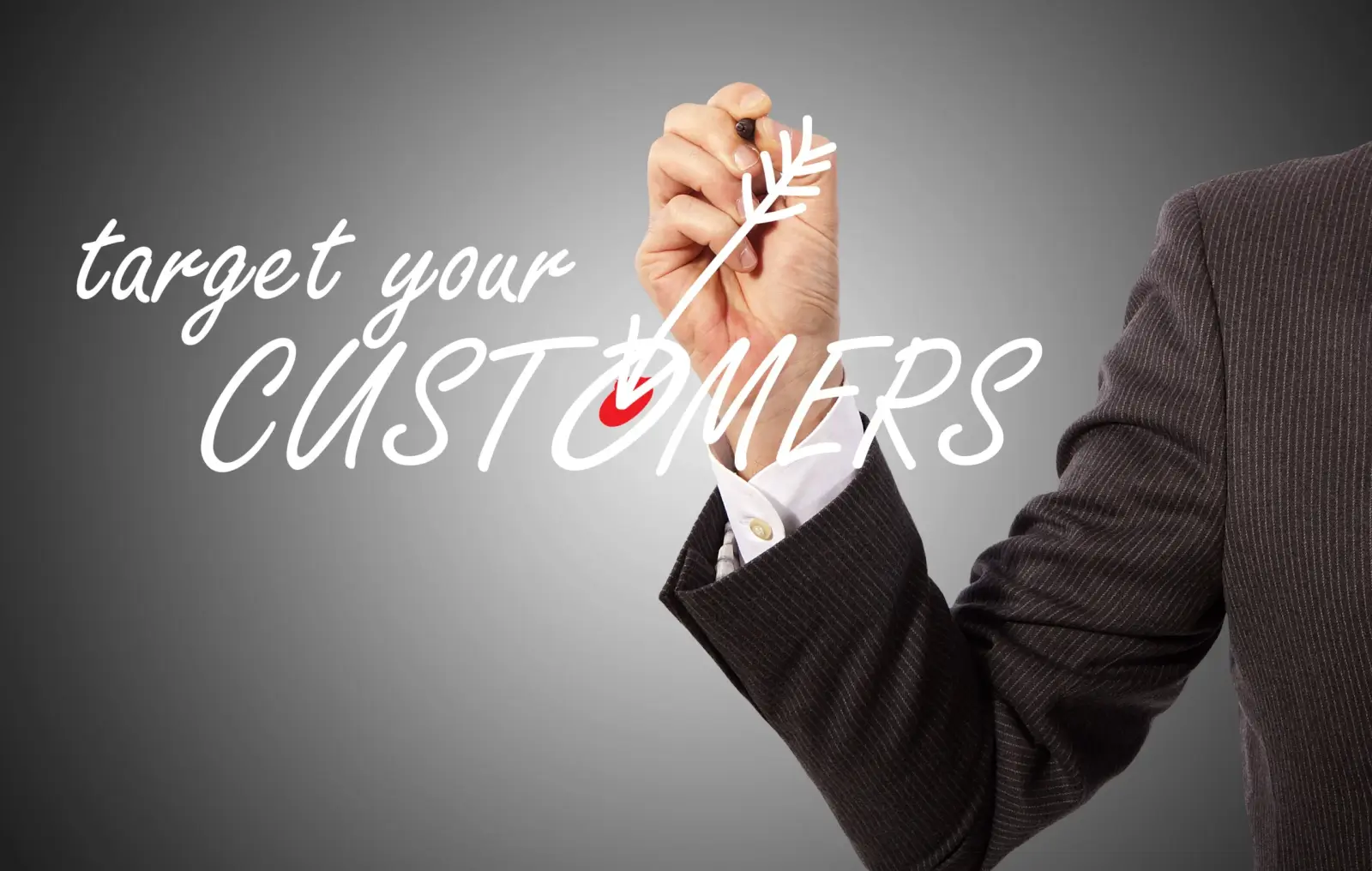 A person in a suit writes "target your CUSTOMERS" on glass with a drawn arrow pointing to the word "CUSTOMERS" against a gradient gray background.